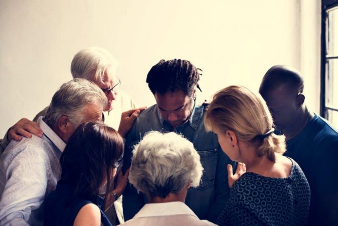 people gathering together in prayer